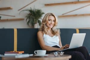 Attractive middle aged blond woman writing her beauty business business plan.