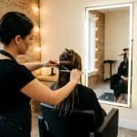 Hair stylist sectioning wet hair with shears in a private salon suite at Venus Salon Suites Frisco