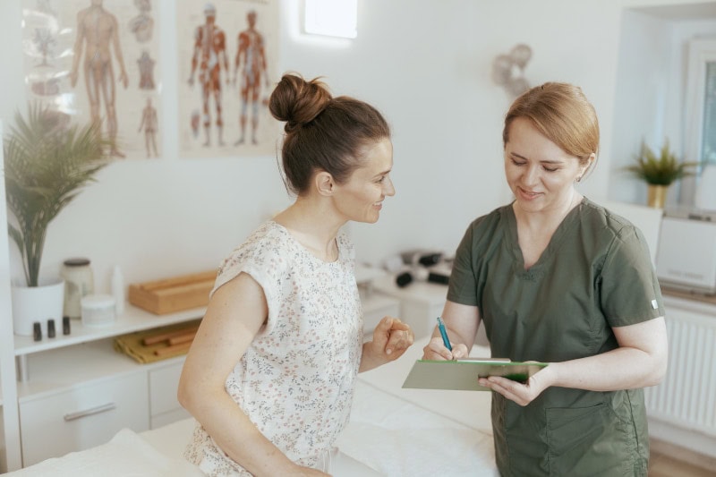 Massage therapist discussing with new patient service upgrades.