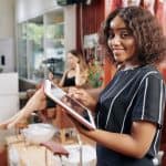 Woman using her table to work out her Hair Salon Business Tax and Insurance Needs